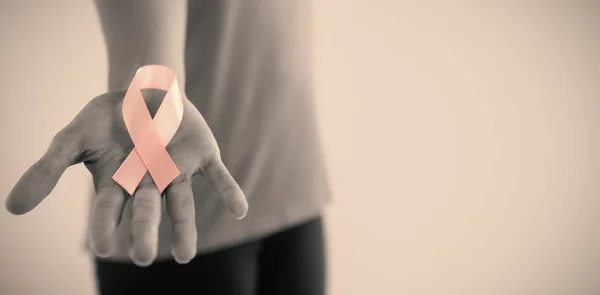 Mujer sosteniendo rosa cáncer de mama conciencia cinta — Foto de Stock