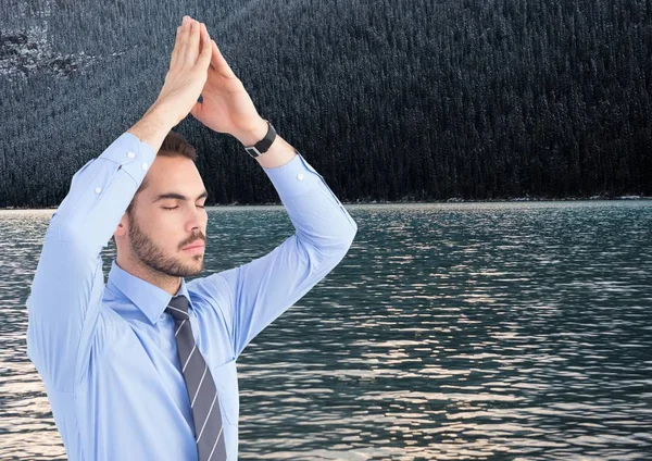 Obchodní muž meditací proti vodě — Stock fotografie