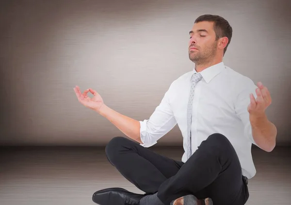 Business man meditating against pink wall — Stock Photo, Image