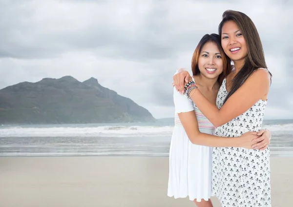 Melhores amigos abraçando contra praia embaçada — Fotografia de Stock