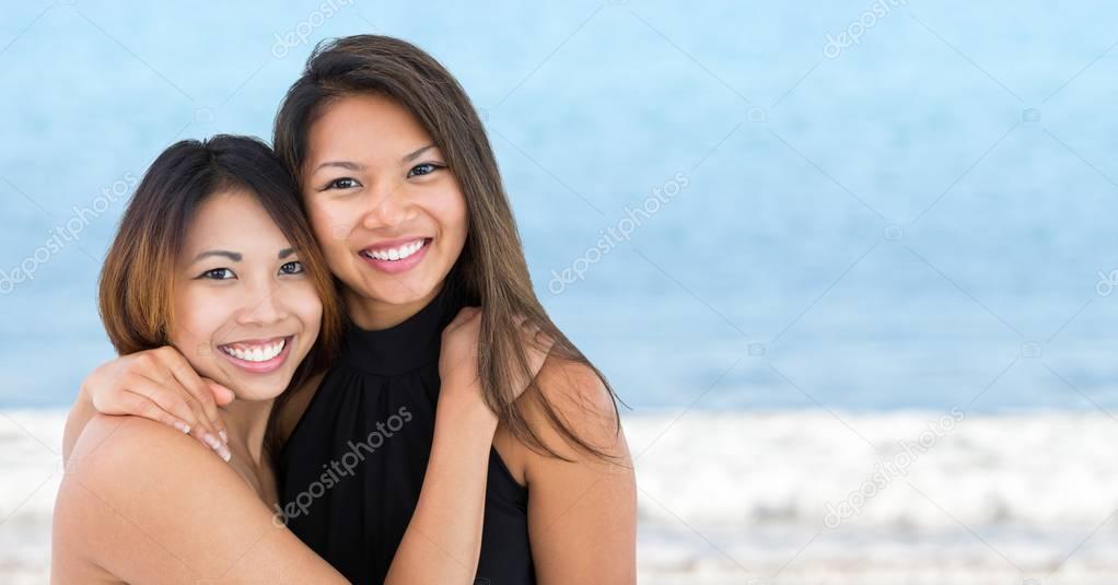 Best friends hugging against blurry water