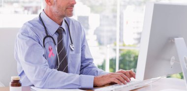 Doktor bilgisayar üzerinde çalışıyor.