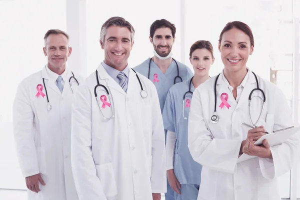 Cancer awareness ribbon against doctors — Stock Photo, Image