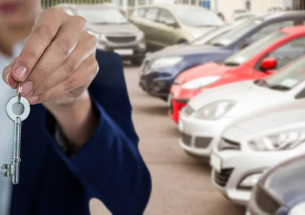 Handen håller nyckeln framför bilar — Stockfoto