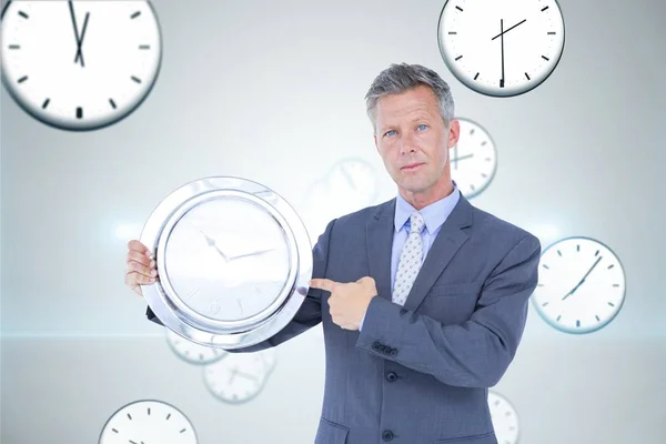 Obchodní muž drží hodiny — Stock fotografie