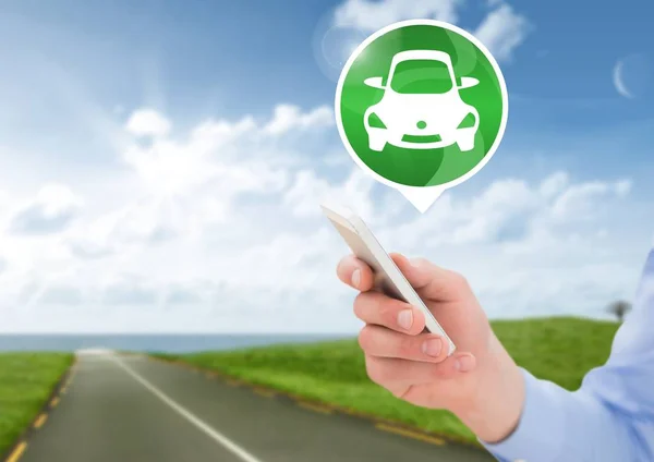 Mão segurando o telefone com o ícone do carro na estrada — Fotografia de Stock