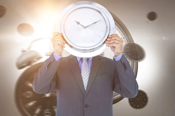 Podnikatel drží nástěnné hodiny — Stock fotografie