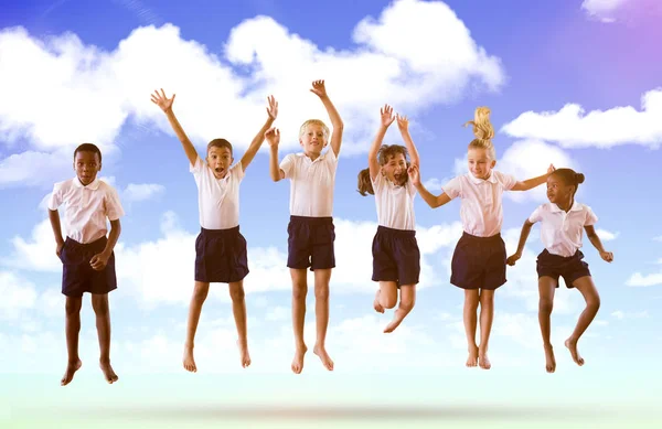 Schüler springen gegen blauen Himmel — Stockfoto