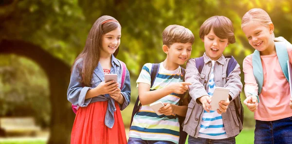 Chłopiec z przyjaciółmi przy użyciu telefonów komórkowych — Zdjęcie stockowe