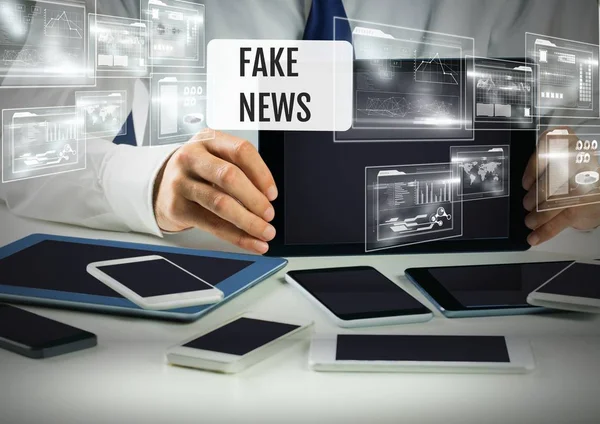 Houden van apparaten met Fake news tekst — Stockfoto