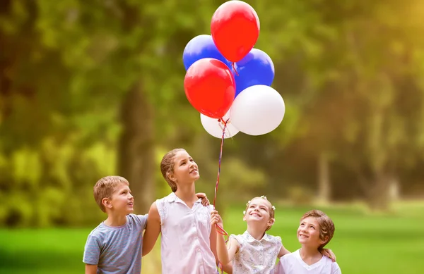 Meisje met vrienden houden ballonnen — Stockfoto