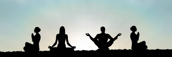 Yoga group silhouette at sunset praying — Stock Photo, Image