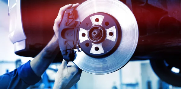 Focused mechanic adjusting wheel at garage — Stock Photo, Image