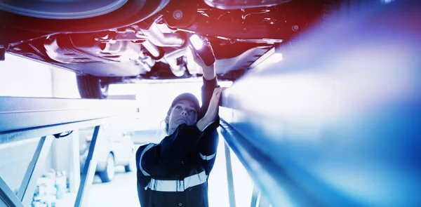 Mechaniker beobachtet unter einem Auto — Stockfoto