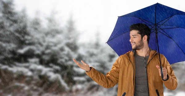 Uomo con ombrello blu nella foresta di neve — Foto Stock
