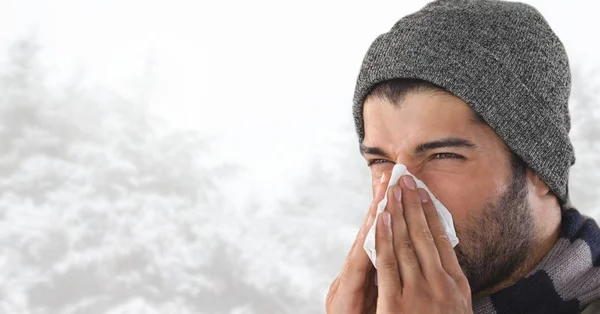 明るい雪の森で彼の鼻を吹く男 — ストック写真