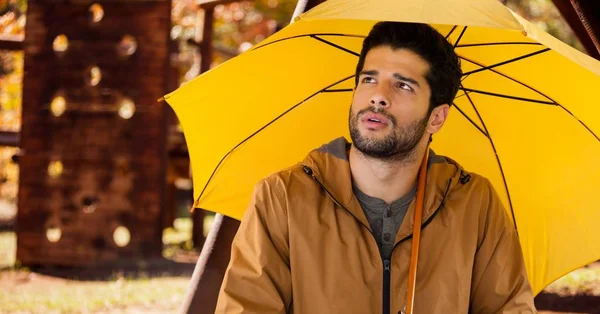 Uomo in autunno con ombrellone nel parco di legno — Foto Stock