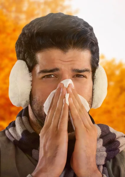 Man in Autumn with earmuffs blowing