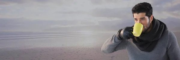 Uomo con sciarpa bere da tazza dal mare — Foto Stock