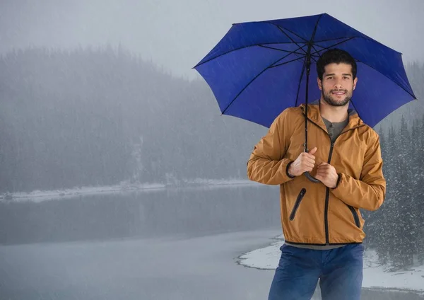 Mann mit Regenschirm über vereisten See — Stockfoto