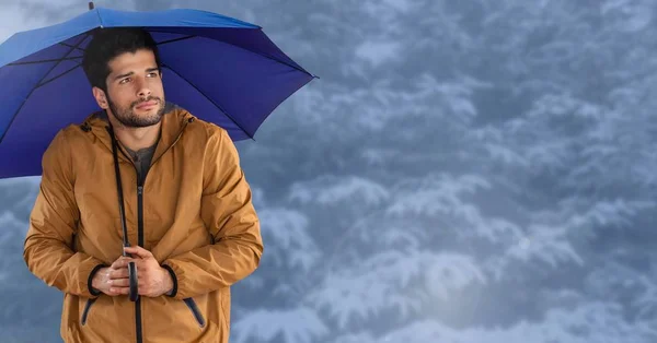 Uomo con ombrello blu nella foresta di neve blu — Foto Stock