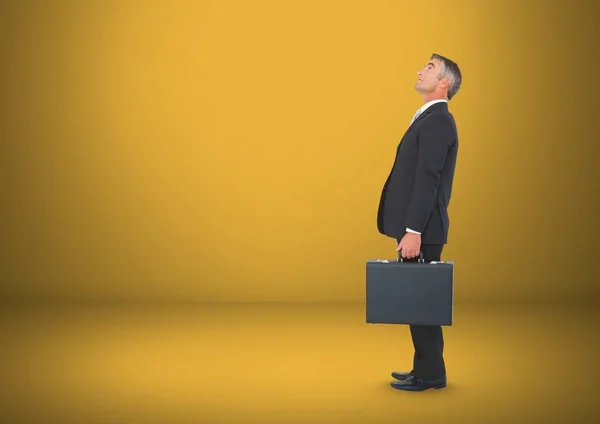 Businessman with briefcase in yellow room — Stock Photo, Image