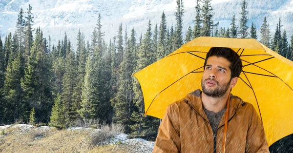 Uomo con ombrello giallo nella foresta — Foto Stock