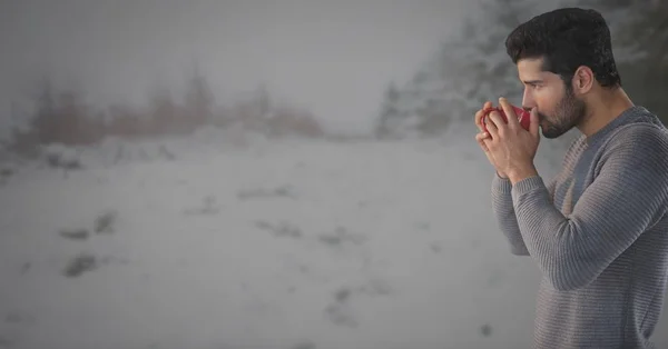 Uomo che beve dalla tazza nel paesaggio della neve — Foto Stock