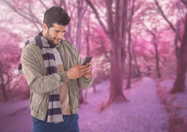 Man in de herfst met telefoon in bos — Stockfoto