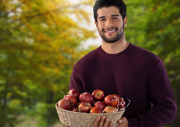 Mann im Herbst mit Korb voller Äpfel — Stockfoto