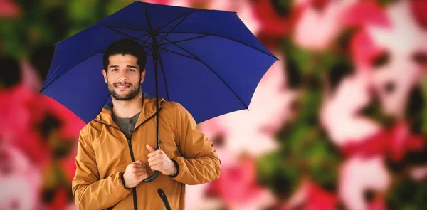 Giovane uomo che tiene l'ombrello blu — Foto Stock