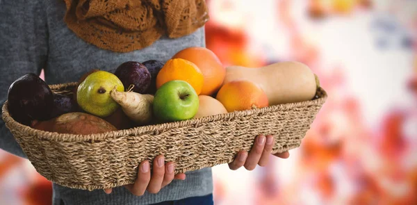 Mujer sosteniendo frutas y verduras en la cesta — Foto de Stock