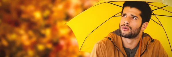 Jovem homem segurando guarda-chuva amarelo — Fotografia de Stock