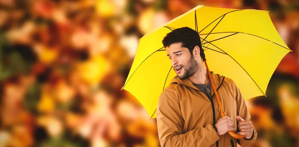 Jovem homem segurando guarda-chuva amarelo — Fotografia de Stock