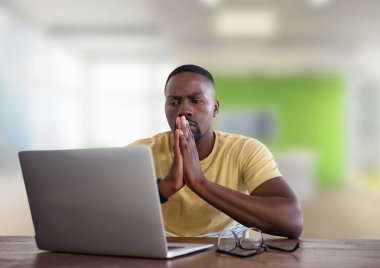 Adam parlak ofiste dizüstü bilgisayar ile masada