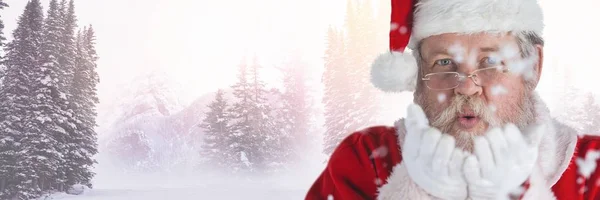 Санта раздувает снег на руках — стоковое фото