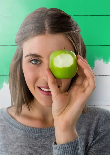 Mujer contra madera con manzana sobre ojo —  Fotos de Stock