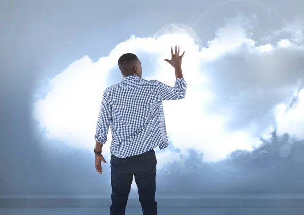 Empresario tocando nubes iluminadas — Foto de Stock