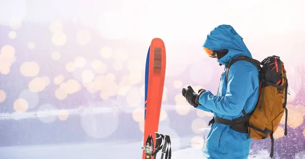 Человек, стоящий с лыжами — стоковое фото