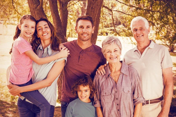 Familia feliz en parque por árbol —  Fotos de Stock