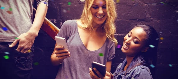 Mulher com amigo usando telefones celulares — Fotografia de Stock