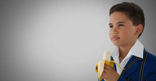 Хлопчик на сірому фоні з бананом — стокове фото