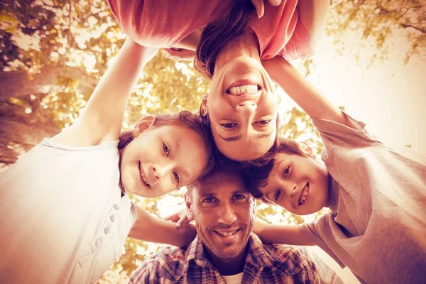 Família feliz no parque se amontoando em círculo — Fotografia de Stock