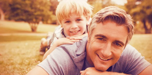 Pai e filho deitados no campo — Fotografia de Stock