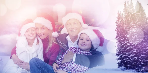 Familj i Santa hatt kramas på soffan — Stockfoto