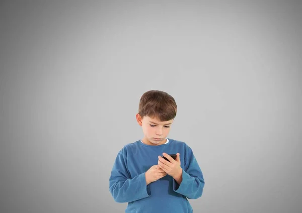 Niño contra fondo gris con teléfono — Foto de Stock