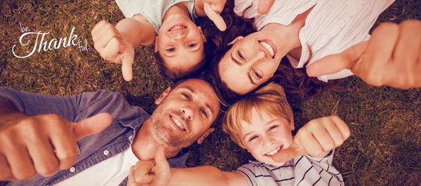 Familjen i parken tillsammans gestikulerande tummen upp — Stockfoto