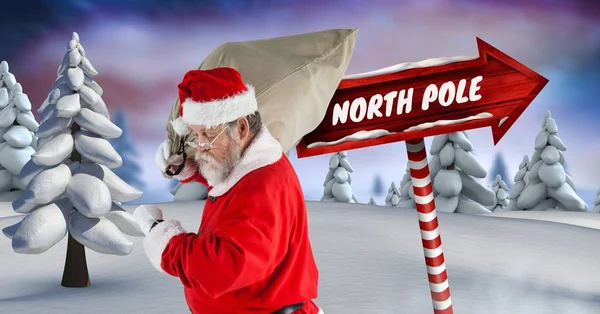 Pólo Norte texto e Santa segurando saco — Fotografia de Stock