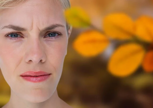 Concerned woman's face in forest with leaves — Stock Photo, Image