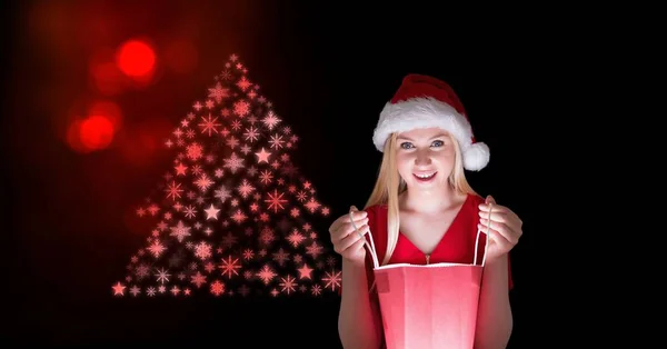 Femme Père Noël à la recherche dans un sac cadeau et motif arbre de Noël flocon de neige — Photo